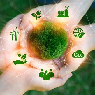 Zwei paar Hände liegen aufeinander. Darüber abstrakt ein aus Moos bestehender Kreis um den Symbole wie Windräder und CO2 angeordnet sind.