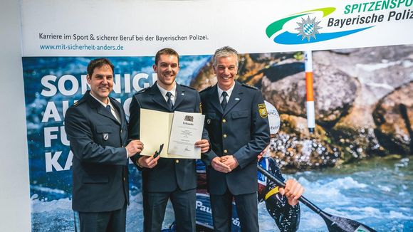  Foto: Bayerische Polizei / Maximilian Dallinger (Mitte) bei der Urkundenübergabe zur Enennung zum Polizeimeister. 